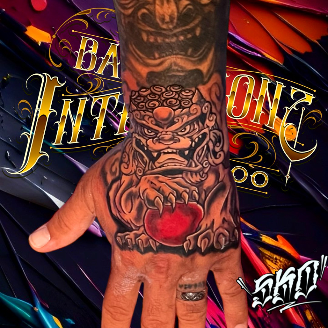 Black and grey Foo Dog hand tattoo with red accents by Bad Intentionz Tattoo, Bloomfield NJ